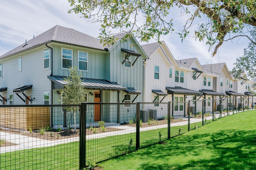 a row of houses behind a fence