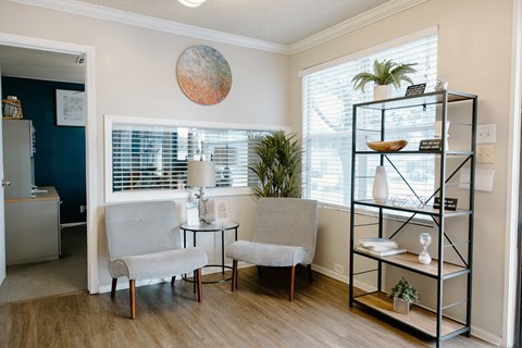 A living room with a grey chair and a small table.