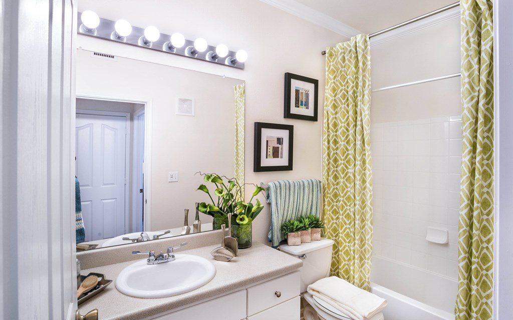 a bathroom with a white sink and a yellow shower curtain