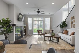 a living room with a fireplace and a ceiling fan