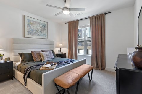 A bedroom with a large bed and a ceiling fan.
