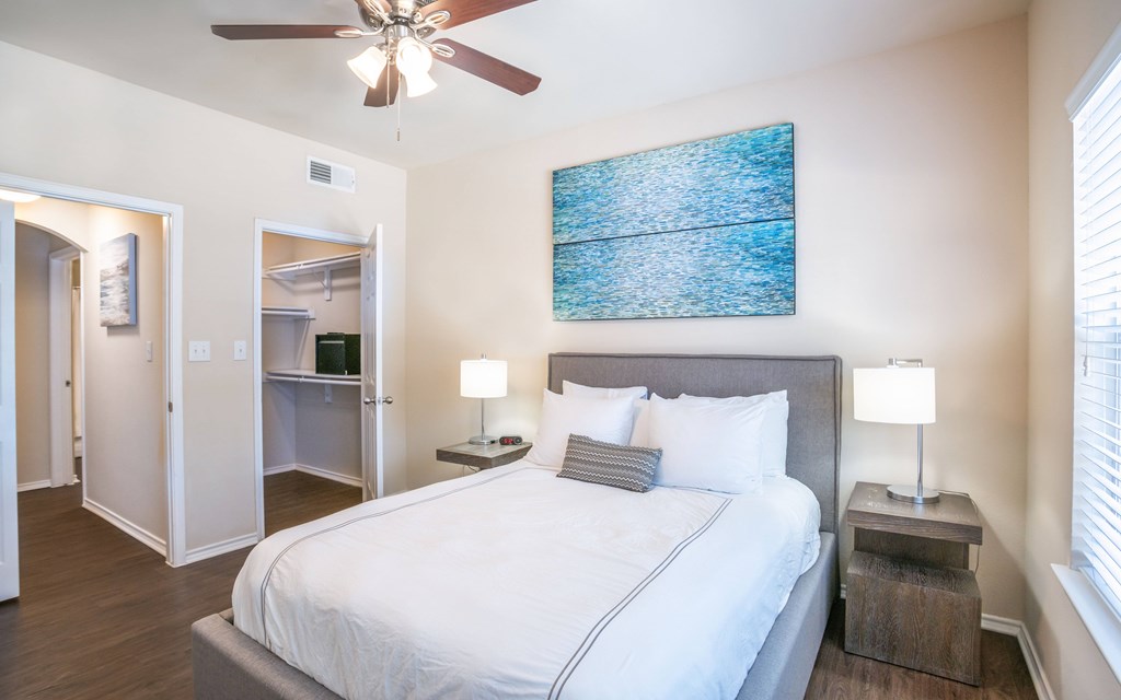 a bedroom with a large bed and a ceiling fan