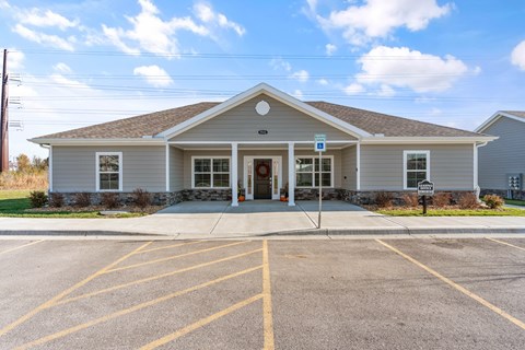 A small building with a parking lot in front.