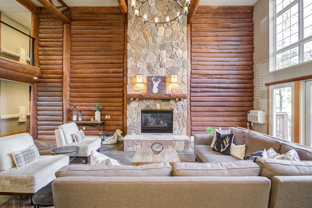 a large living room with a stone fireplace and couches