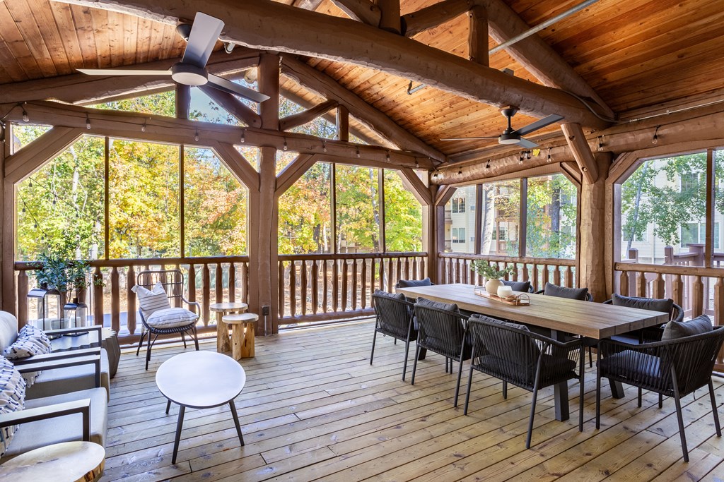 a screened in porch with a dining table and chairs