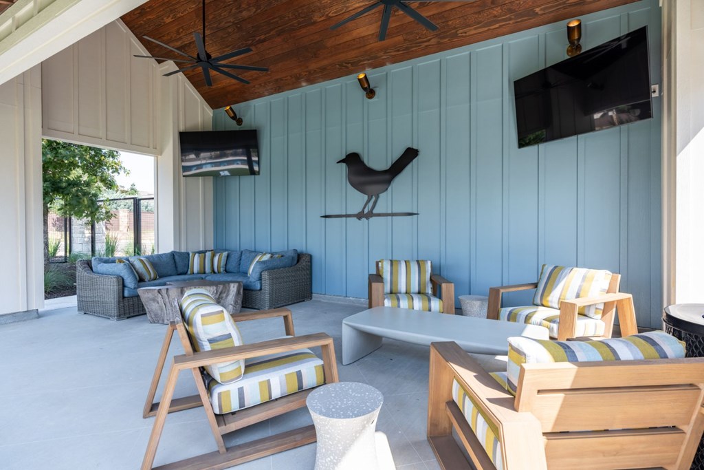 a patio with couches and chairs and a tv