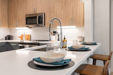 A modern kitchen with a white countertop and a microwave above it.