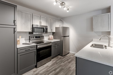 our spacious kitchen is equipped with stainless steel appliances and white quartz counter tops