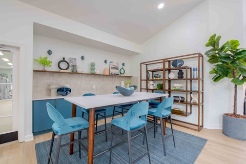 A dining room with a white table and blue chairs.
