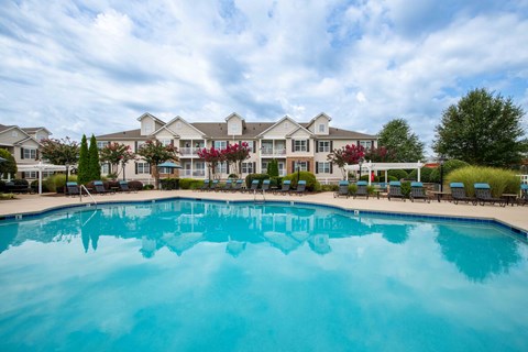 A large swimming pool in front of a resort-style building.