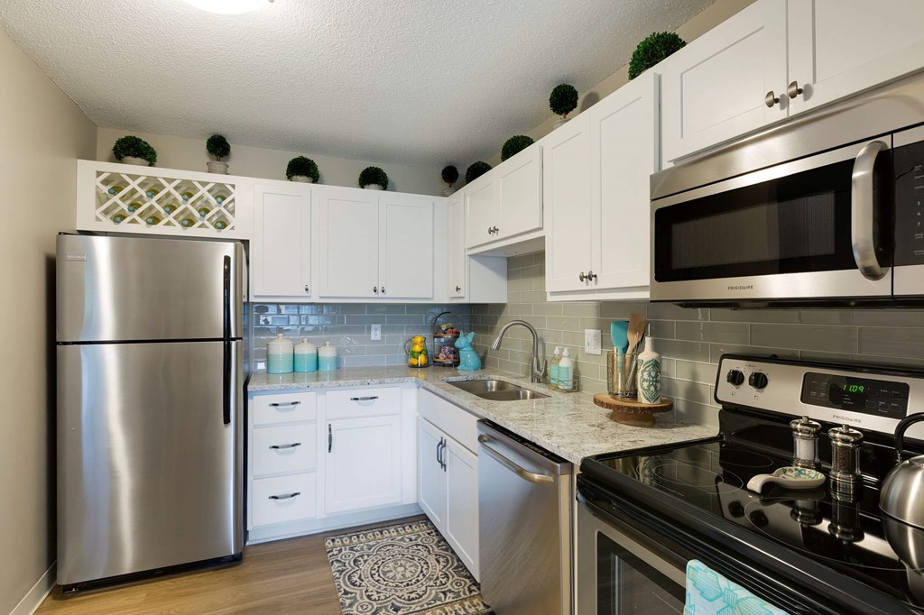a kitchen with stainless steel appliances and white cabinets