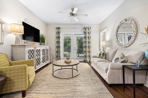 A living room with a yellow chair and a white couch.