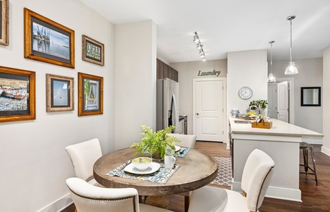 A dining room with a table set for two and a laundry sign on the wall.