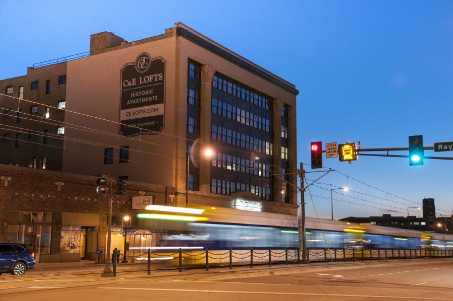 a train is going down the street in front of a building