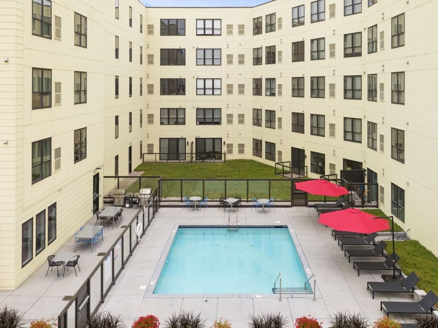Outdoor pool and patio area with grills and fireplace