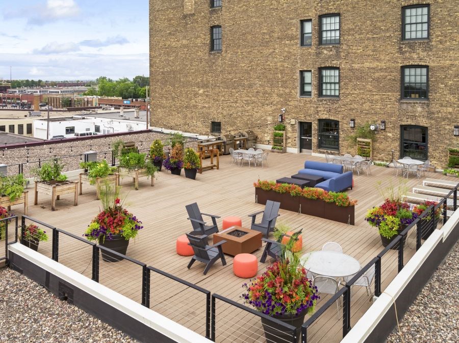 Rooftop terrace with lounging furniture, grills, and fireplaces