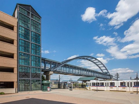 a train is parked in front of a building with an overpass