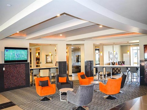 a lobby with chairs and a bar and a television
