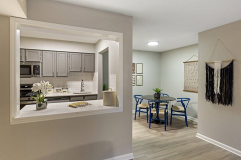 A kitchen with a dining table and chairs.