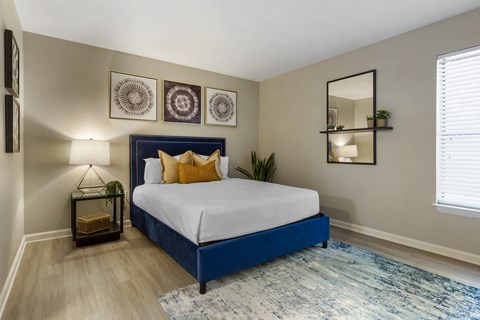 A bedroom with a blue bed and a white bedspread.