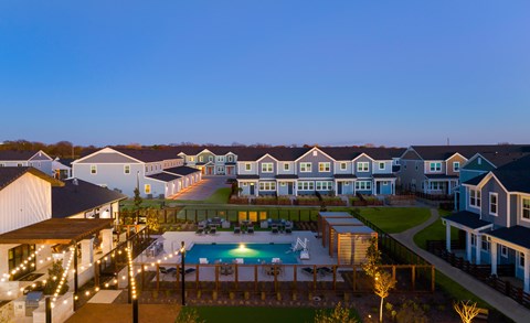 A row of houses with a pool in the foreground.