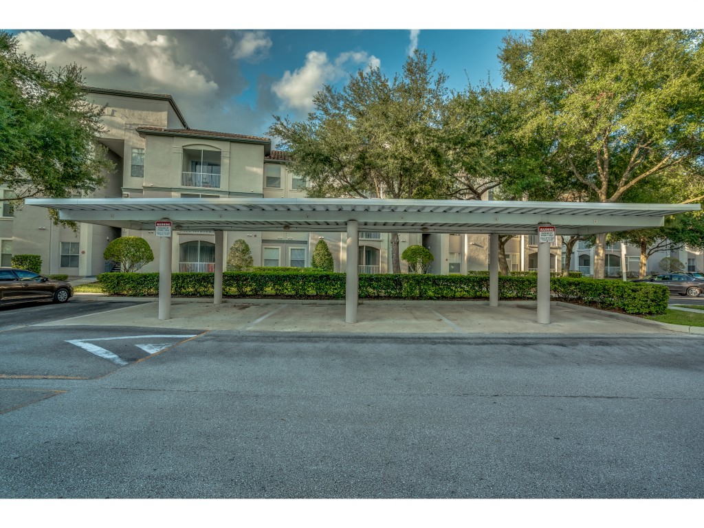 a covered parking lot in front of an apartment building