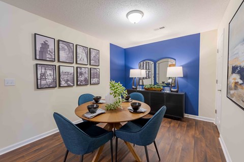 A dining room with a wooden table and blue chairs.