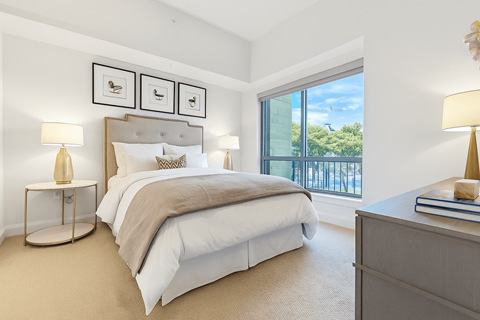 A bedroom with a large bed and a view of the outside.