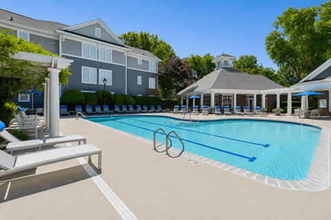 A swimming pool with a diving board and a white pillar.