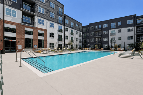 A swimming pool in front of apartment buildings.