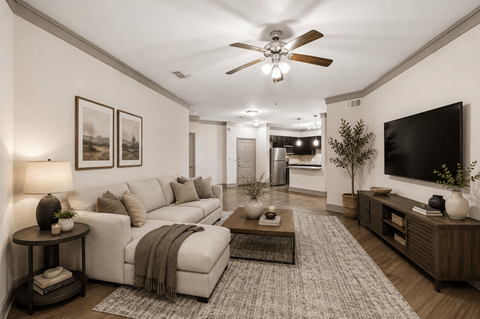 A living room with a white couch and a ceiling fan.