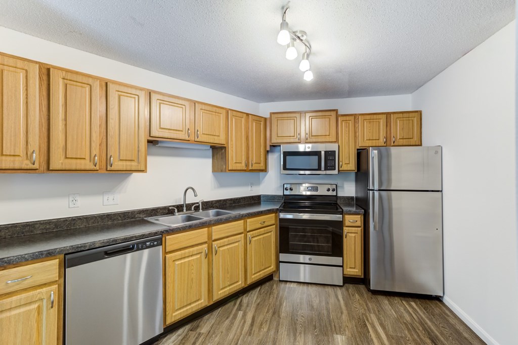 a kitchen with wooden cabinets and stainless steel appliances