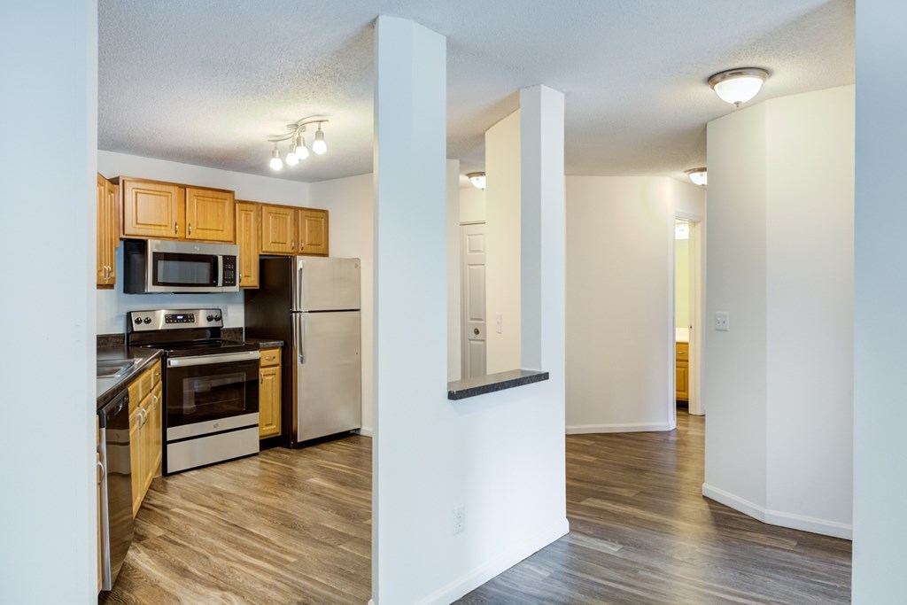 a kitchen and living room with wood floors and white walls