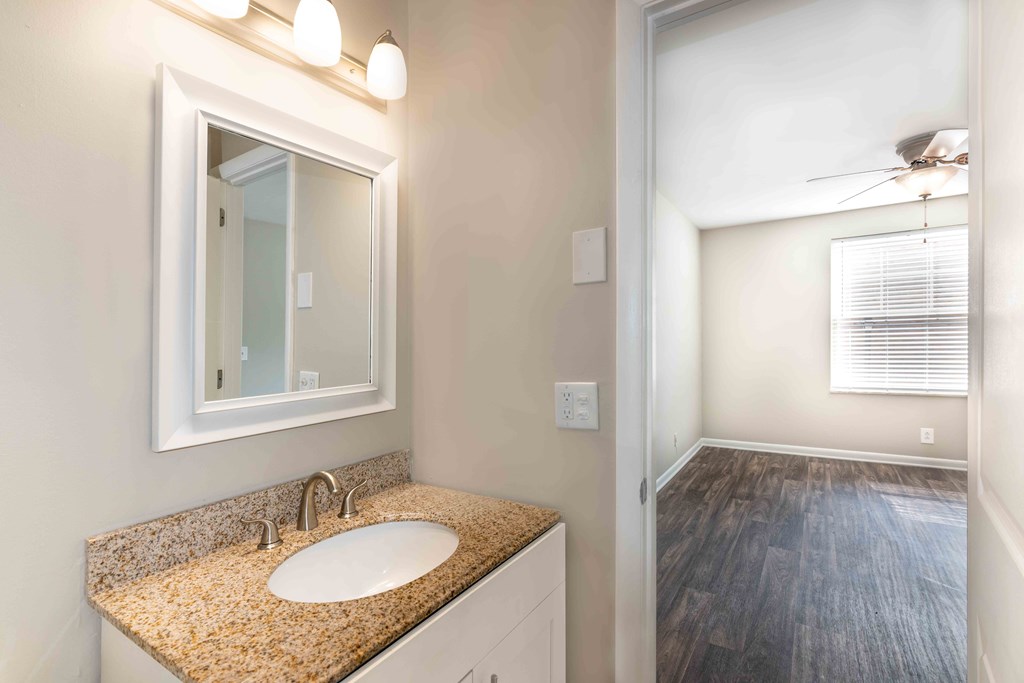 Condos in Murfreesboro TN - Condos at the Villager - Bathroom with a Granite-Style Sink and a Large Mirror Vanity