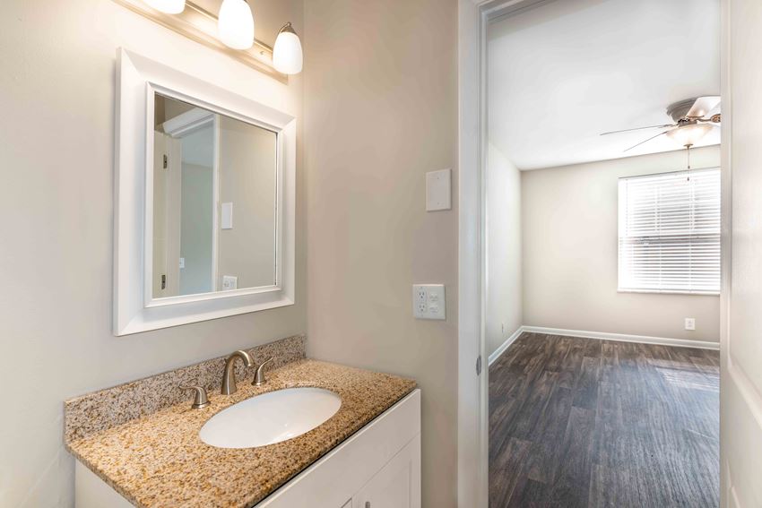 Condos in Murfreesboro TN - Condos at the Villager - Bathroom with a Granite-Style Sink and a Large Mirror Vanity
