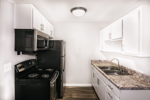 Murfreesboro TN Apartments - Condos at the Villager - Kitchen with Granite-Style Countertops and White Cabinets