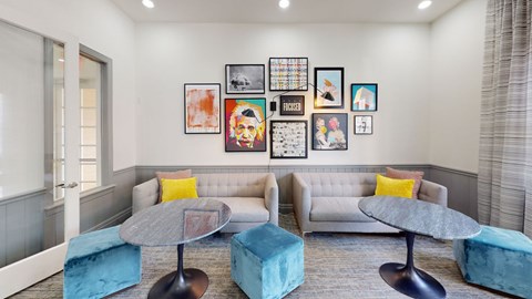 a living room with couches and chairs and a wall of pictures