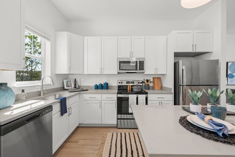A modern kitchen with white cabinets and stainless steel appliances.