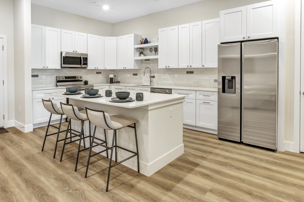 a large kitchen with white cabinets and stainless steel appliances