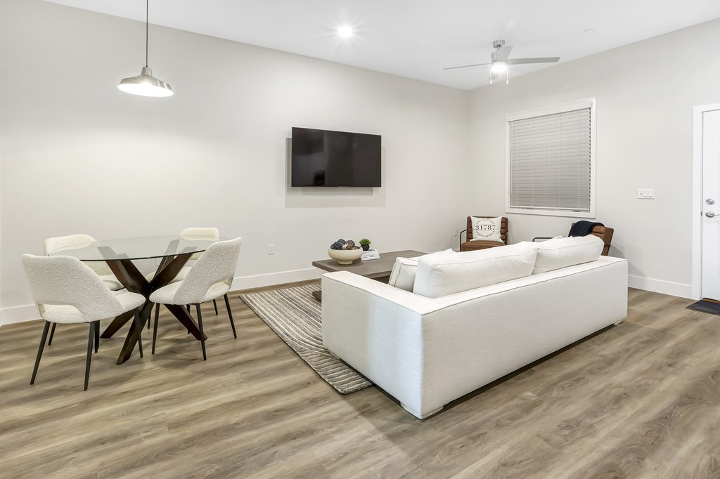 a living room with a white couch and a table with chairs