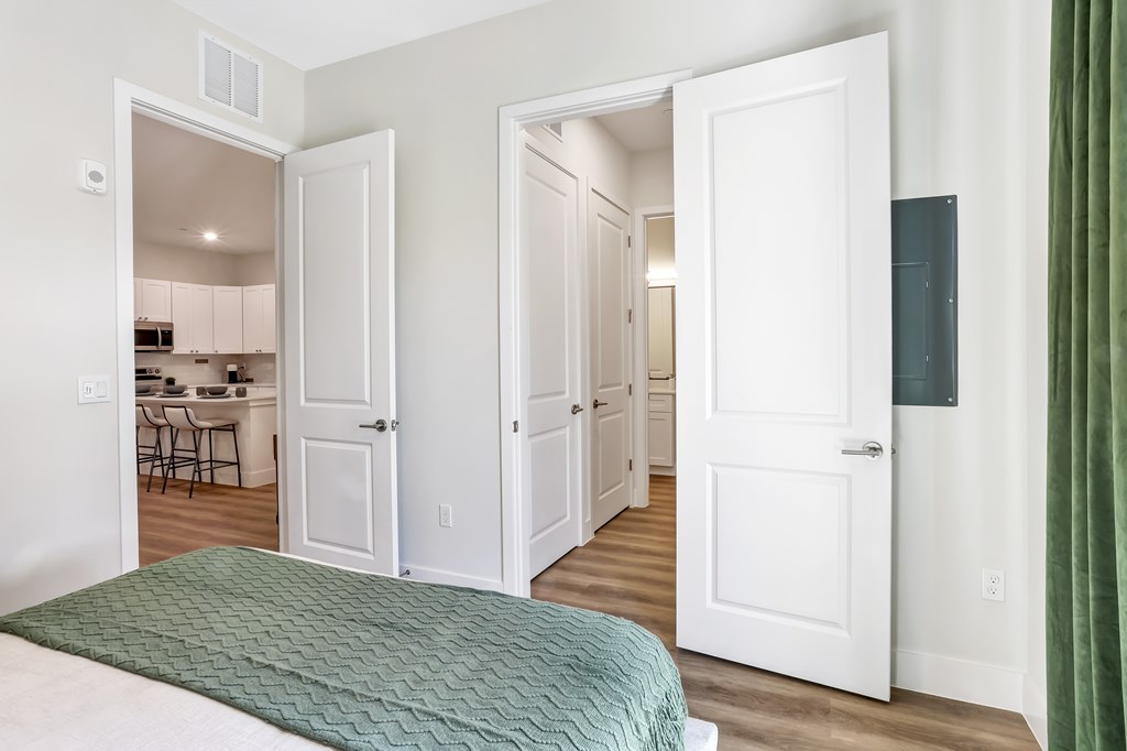 a bedroom with a bed and a doorway to a kitchen