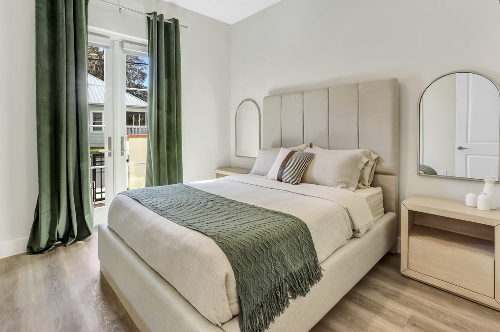 a bedroom with a bed and a window with green curtains