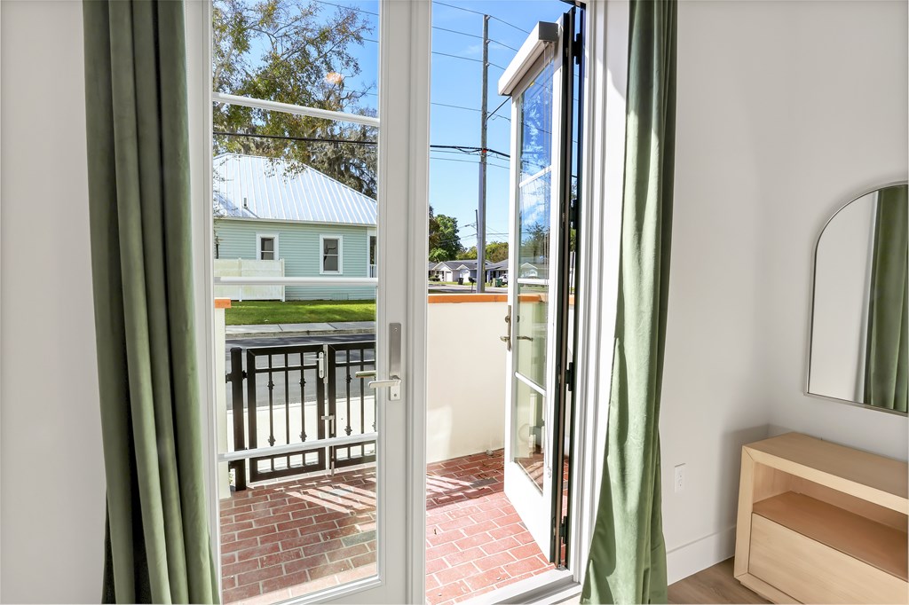 a view of a balcony from a room with open doors