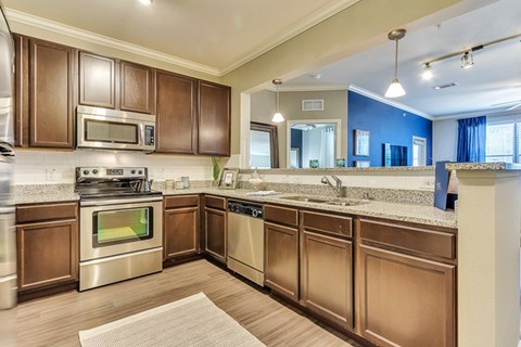 A kitchen with brown cabinets and stainless steel appliances.