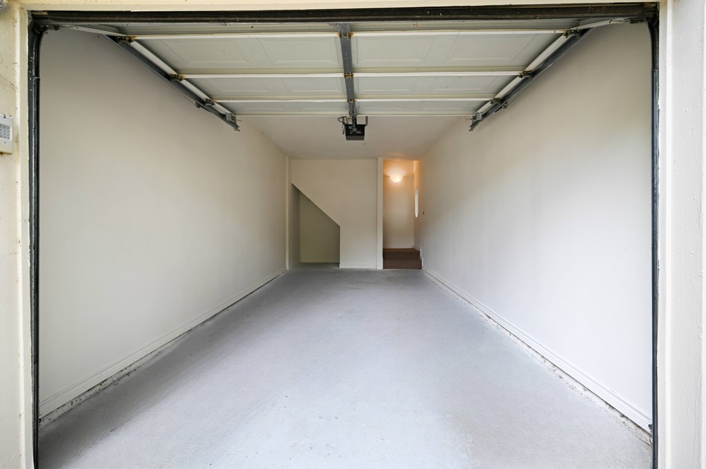 a empty room in a garage with a white wall