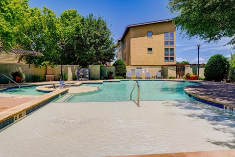 A swimming pool with a building in the background.