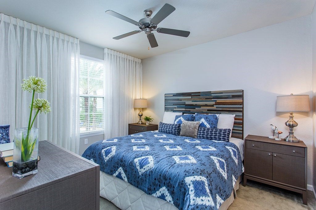 a bedroom with a bed and a ceiling fan