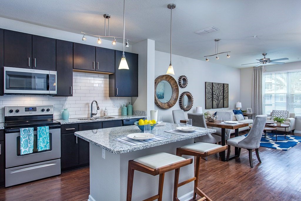 a kitchen and living room with a marble counter top