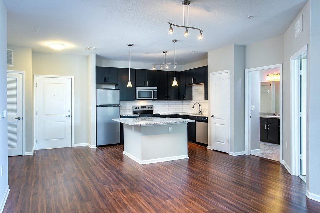 an empty kitchen with an island and stainless steel appliances