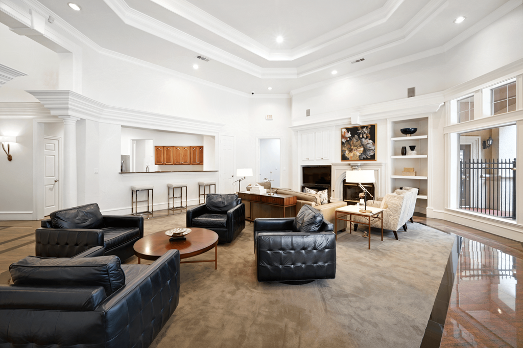 a living room with black leather furniture and a fireplace